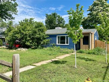 Charming blue house with tidy front yard and walkway leading to the entrance at 1701 W 50Th Ave, Denver, CO 80221