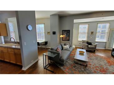 Bright living room with hardwood floors, stylish rug, and comfortable gray sofa at 475 W 12Th Ave # 8H, Denver, CO 80204