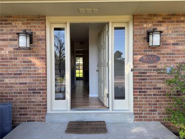 Inviting front entrance featuring a charming brick facade and updated exterior lights at 10366 E Ida Ave, Greenwood Village, CO 80111