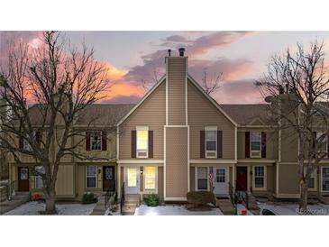 Tan-colored townhome exterior with a charming front entrance and landscaping at 1811 S Quebec Way # 151, Denver, CO 80231