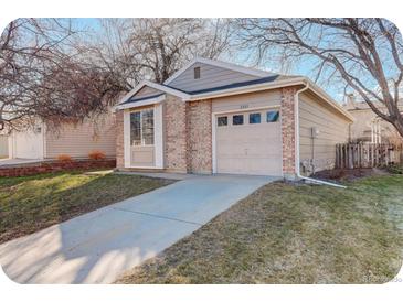 Charming single-story home featuring a brick facade, attached garage, well-maintained lawn, and inviting curb appeal at 2335 E Cherrywood Dr, Lafayette, CO 80026