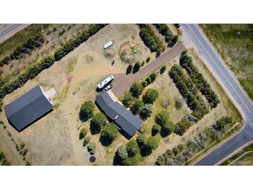 Expansive property featuring a home, additional structure, and mature landscaping, all captured from an aerial perspective at 12518 N Dixon Dr, Parker, CO 80138