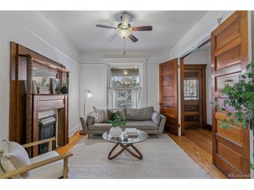 Cozy living room featuring a decorative fireplace, modern sofa, and hardwood floors at 39 S Grant St, Denver, CO 80209