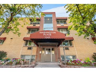 Exterior front view of Washington Place apartment building with brick facade and covered entry at 1243 N Washington St # 308, Denver, CO 80203