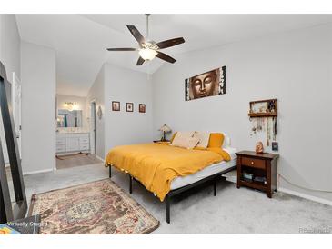 Bright main bedroom featuring a ceiling fan, modern décor, and ensuite bathroom at 2954 E 101St Ave, Thornton, CO 80229