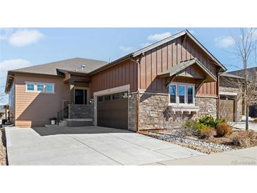 Beautiful home exterior featuring stone accents, wood siding, well-maintained landscaping, and a spacious driveway at 3598 New Haven Cir, Castle Rock, CO 80109