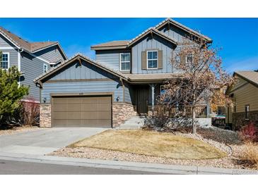 Charming two-story home featuring stone accents, a covered porch, and a well-maintained front yard in a suburban neighborhood at 655 Tiger Lily Way, Highlands Ranch, CO 80126