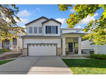 Charming two-story home with a two-car garage, covered porch and well-manicured lawn at 22142 E Belleview Place, Aurora, CO 80015