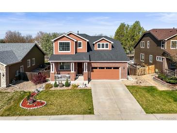 Charming two-story home with a brick facade, a two-car garage, and a beautifully landscaped front yard at 11373 Kearney Way, Thornton, CO 80233