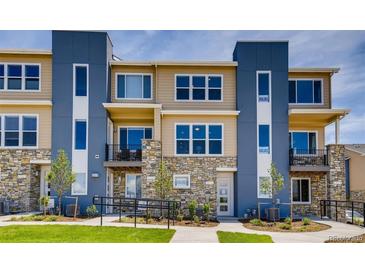 Modern townhome featuring stone accents, multiple windows, and private balconies at 6737 S Tempe Ct, Aurora, CO 80016