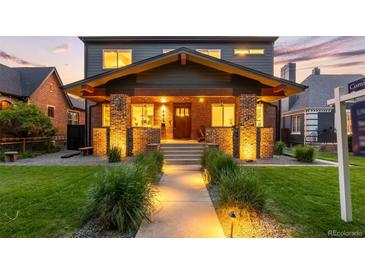 Stunning two-story home with a brick facade, inviting front porch, and lush green lawn with inviting walkway at 2669 N Cherry St, Denver, CO 80207