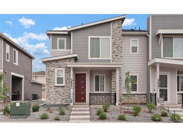 Stylish two-story townhouse featuring modern design elements, a red front door, and low-maintenance landscaping at 22863 E Tufts Ave # A, Aurora, CO 80015