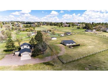 Expansive aerial view of a home with pastures, outbuildings, and fencing at 17800 E Hinsdale Ave, Foxfield, CO 80016