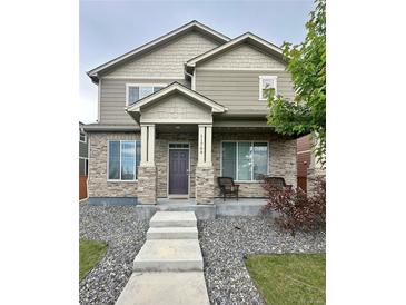 Charming two-story home with stone accents, covered porch, and manicured front yard at 11709 Park South Ln, Parker, CO 80138
