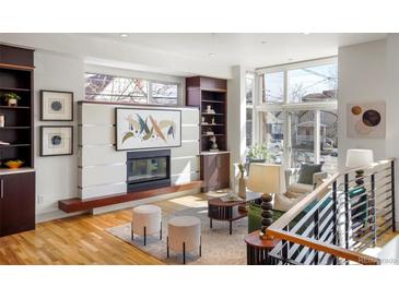 Bright living room boasts a modern fireplace, large windows, and stylish furnishings, creating an inviting and sophisticated space at 2518 N Washington St, Denver, CO 80205