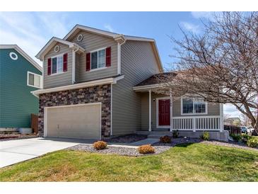 Charming two-story home featuring stone accents, a well-manicured lawn, and a welcoming front porch at 5549 Helena St, Denver, CO 80239