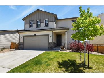 Charming two-story home featuring a well-manicured lawn, attached garage, and a welcoming front porch at 6404 Dry Fork Dr, Frederick, CO 80516