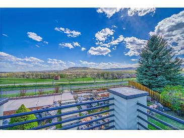 Scenic view from the back of the property featuring landscaping, open fields, and distant mountains at 17280 W 70Th Ave, Arvada, CO 80007