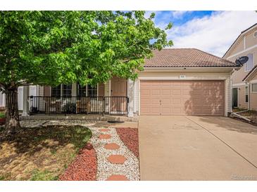 Charming single-Gathering home featuring a cozy front porch, two-car garage, and meticulous landscaping at 19481 E 50Th Pl, Denver, CO 80249