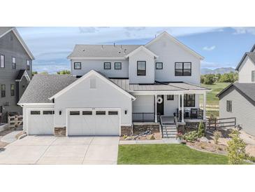 Beautifully designed two-story home featuring a charming front porch, three-car garage, and modern architectural details at 2141 Fountain Cir, Erie, CO 80516
