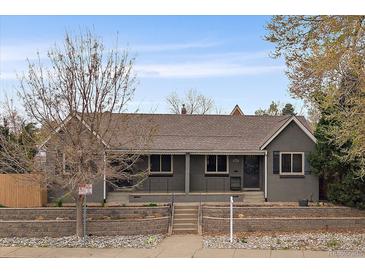 Charming one-story home with a brick facade, a covered porch, and a well-manicured front yard at 3327 Irving St, Denver, CO 80211