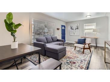 Bright living room with modern decor, hardwood floors, and a large window at 3385 Olive St, Denver, CO 80207