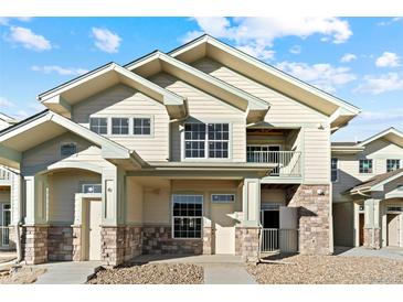 Charming two-story townhome featuring stone accents, a cozy porch, and a private balcony at 18633 Stroh Rd # 2-104, Parker, CO 80134