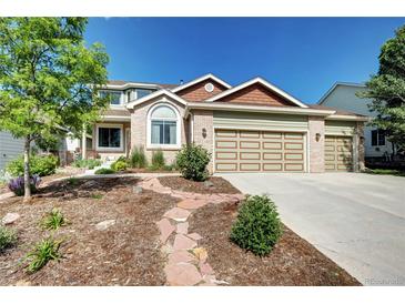 Charming two-story brick home with a well-maintained front yard and a three-car garage at 1313 Iris Cir, Broomfield, CO 80020