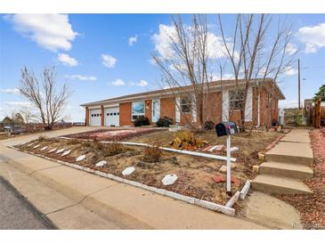 Charming brick home with a two-car garage and a cozy front yard at 7412 W 76Th Ave, Arvada, CO 80003
