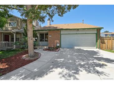 Charming single-Gathering home featuring a well-manicured lawn, brick accents, and attached two-car garage at 9125 Lowell Ct, Westminster, CO 80031