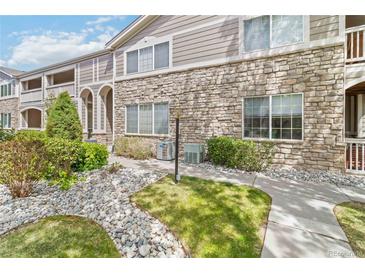 Inviting two-story condo with manicured landscaping, stone facade, and charming architectural details at 4222 S Blackhawk Cir # 6C, Aurora, CO 80014