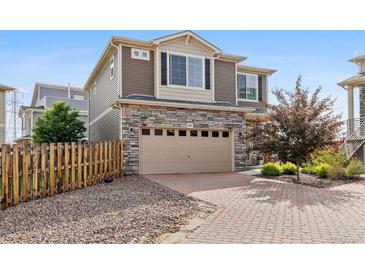 Beautiful two-story home with a stone facade and brick driveway at 242 S Old Hammer Ct, Aurora, CO 80018