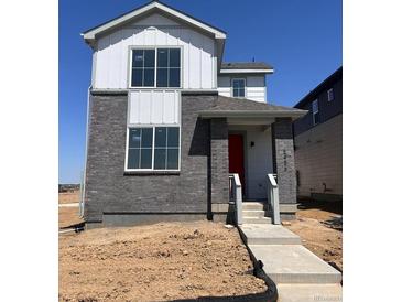 Two-story home showcasing a gray brick facade, white accents, large windows, and a vibrant red front door at 5456 N Elk St, Aurora, CO 80019