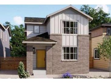 Charming two-story home featuring a brick facade, yellow door, and modern architectural details at 5456 S Elk Way, Aurora, CO 80016
