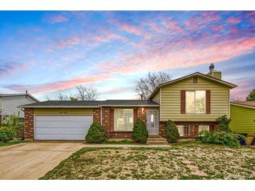 Charming home featuring a well-maintained lawn, brick accents, and a two-car garage at 4640 Fairplay Way, Denver, CO 80239