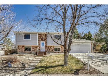 Split level home with brick and siding, landscaped front yard, and inviting walkway at 18056 E Mansfield Ave, Aurora, CO 80013