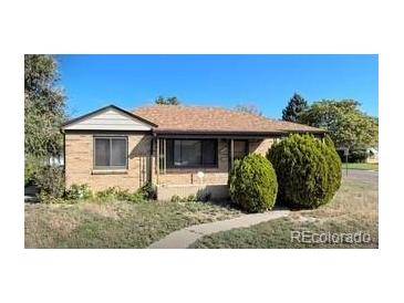 Charming single-story home with a brick exterior and a well-maintained front yard, perfect for a Gathering at 7555 E 22Nd Ave, Denver, CO 80207