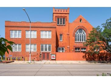 Red brick exterior of a converted loft featuring unique architectural details, large windows, and a welcoming entrance at 225 N Lincoln St # 4, Denver, CO 80203