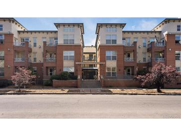 Inviting brick apartment building featuring balconies, mature trees, and attractive architectural details at 1747 N Pearl St # 306, Denver, CO 80203