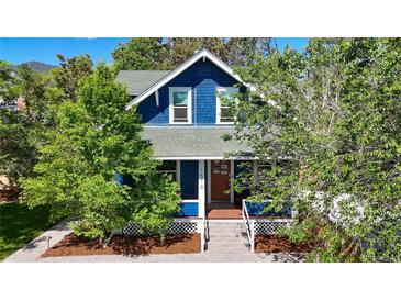 Charming blue home with a welcoming front porch and lush green trees at 1519 16Th St, Boulder, CO 80302
