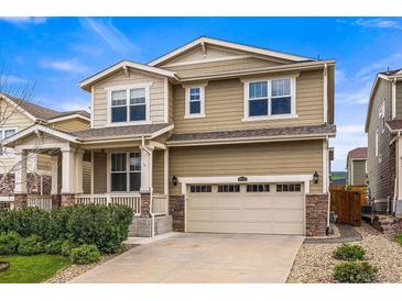 Charming two-story home featuring a front porch, two-car garage and manicured landscaping at 19722 W 59Th Ave, Golden, CO 80403