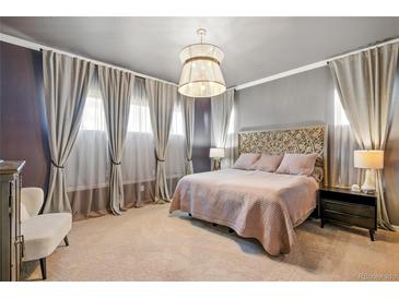 This bedroom features large windows with stylish curtains, a decorative headboard, and a unique pendant light fixture at 17240 Hop Clover Ave, Parker, CO 80134