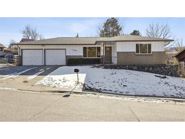 Ranch style home with attached two-car garage and landscaped yard at 17200 W 15Th Ave, Golden, CO 80401