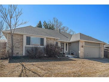 Charming brick and stucco home featuring an attached garage, neutral colors and well-manicured front yard at 4544 W 69Th Ave, Westminster, CO 80030