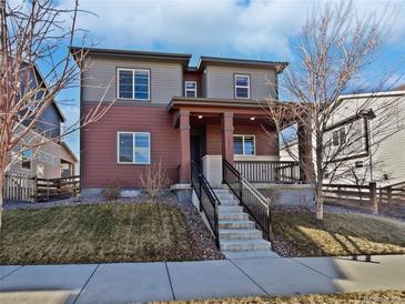 Charming two-story home with well-maintained landscaping and inviting front porch at 10689 Uravan St, Commerce City, CO 80022