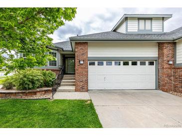 Charming home featuring a two-car garage, brick accents, and a well-manicured lawn and garden at 8267 S Sicily Ct, Aurora, CO 80016