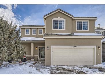 Two-story house with beige siding, attached garage, and landscaping at 12460 S Hollow Creek Ct, Parker, CO 80134