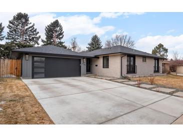 Charming single-story home featuring a modern garage door, inviting walkway, and updated exterior paint at 3049 S Vine St, Denver, CO 80210