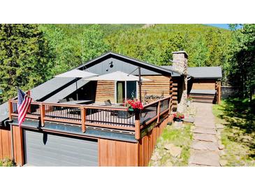 Rustic log home with a large deck, perfect for enjoying the surrounding natural beauty at 10439 Christopher Dr, Conifer, CO 80433