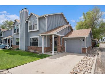 Charming gray two-story home with brick accents, attached garage, and well-manicured lawn at 5250 Cody St, Arvada, CO 80002